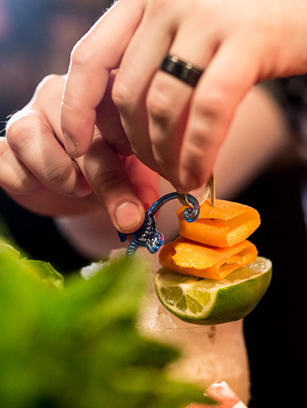 Guests looking on as bartender showing how to mix a cocktail